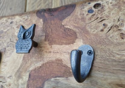 close up owl hanger and single hook on oak burr slab